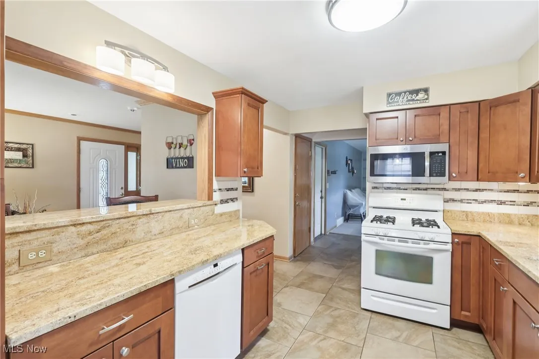 Kitchen with white appliances, Granite countertop, cupboards and breakfast bar