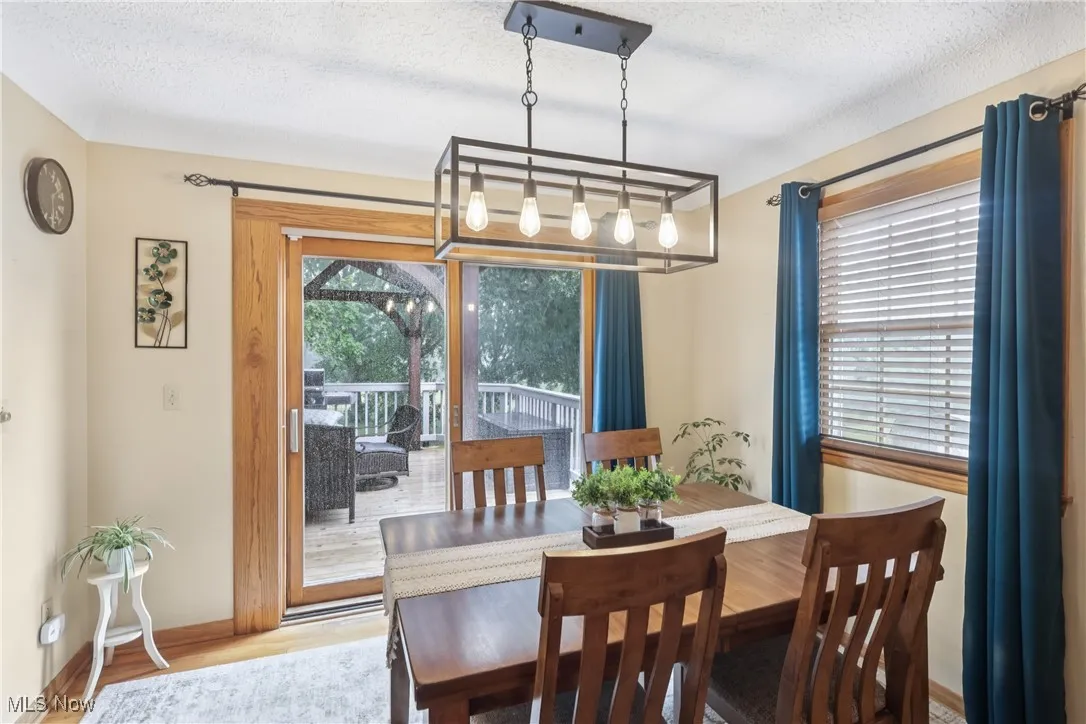 Dining room with chandelier, sliders to the back deck and wood flooring