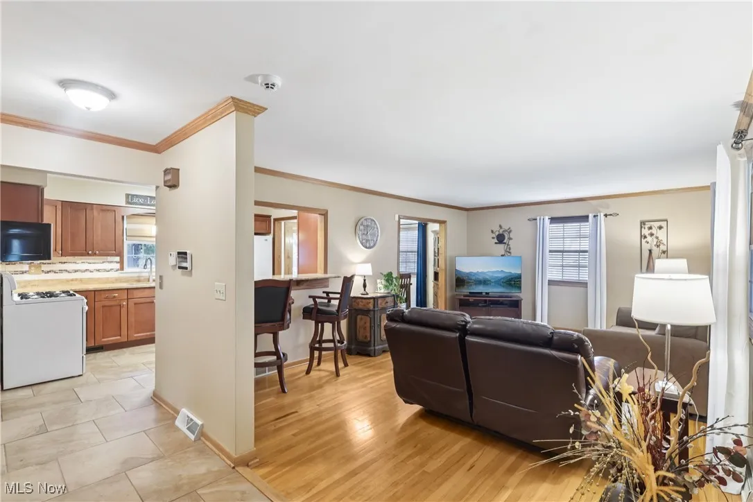 View of the living room with a breakfast bar, wood flooring and the kitchen