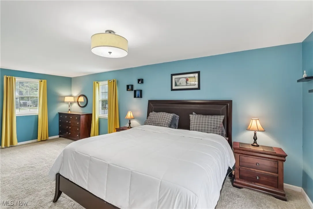 Primary bedroom with a balcony and carpet flooring