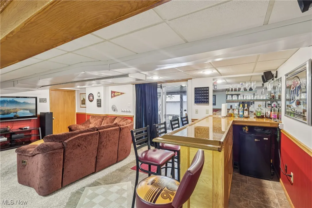 Lower level recreation room with bar area and slider to the heated 4 season / sun room