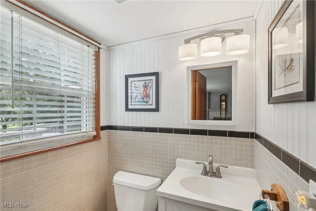 First floor half bath with sink / vanity, special lighting and commode