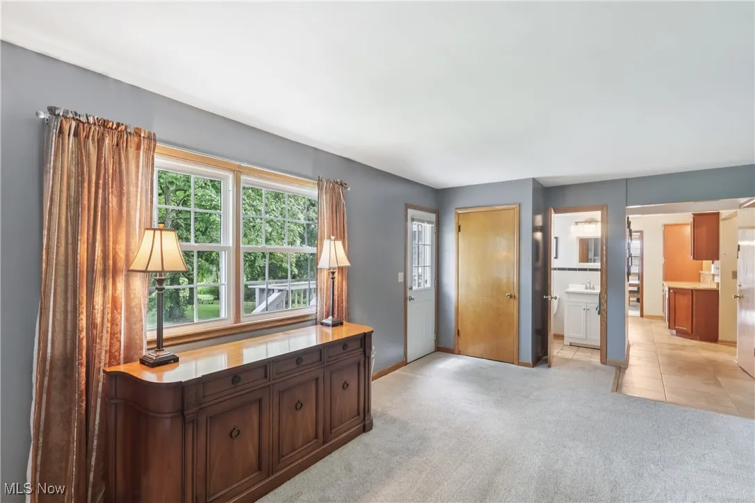 family room with back door entrance and carpet flooring