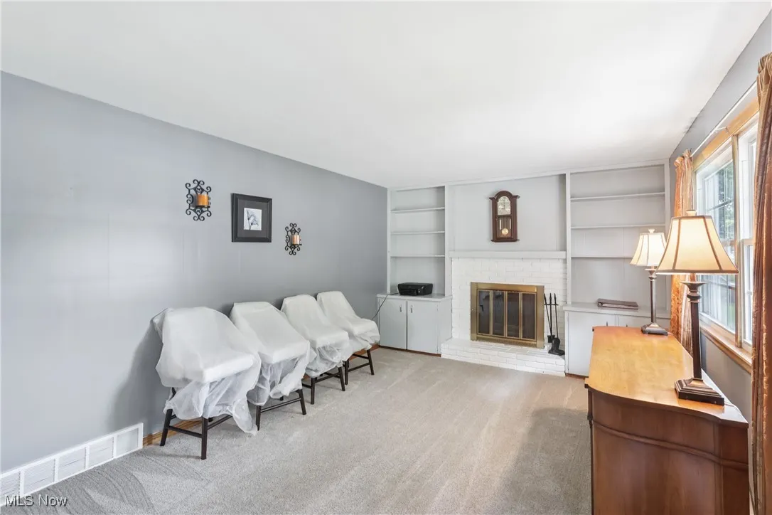 Family room with fireplace, built-in shelves / bookcases and carpet flooring