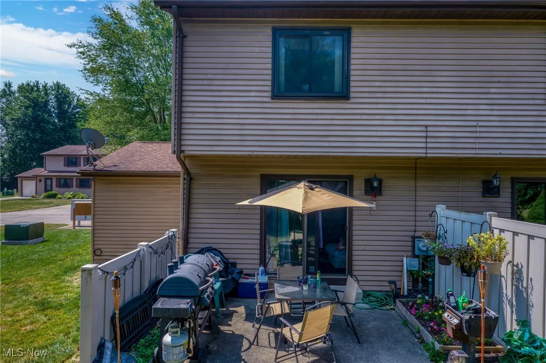 Back of house with a patio and a lawn