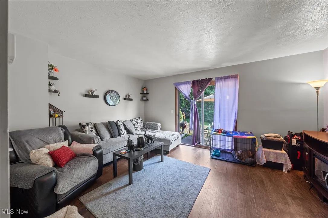 Living area with wood finished floors and a textured ceiling
