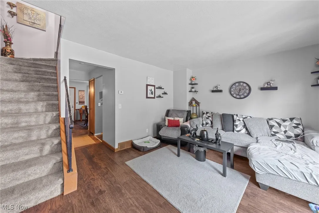Living room with stairway and wood finished floors