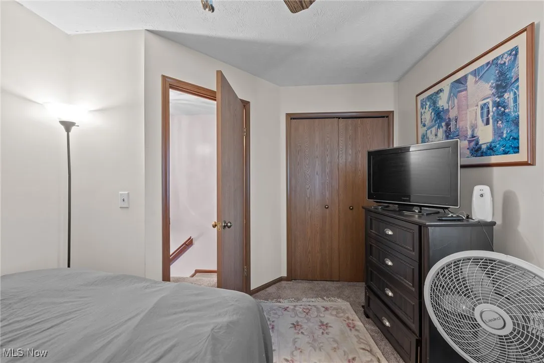 Bedroom featuring a closet, light carpet, and a ceiling fan