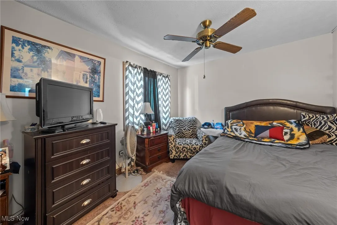 Bedroom with light colored carpet and ceiling fan