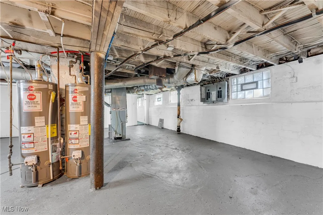 Basement featuring water heater and heating unit