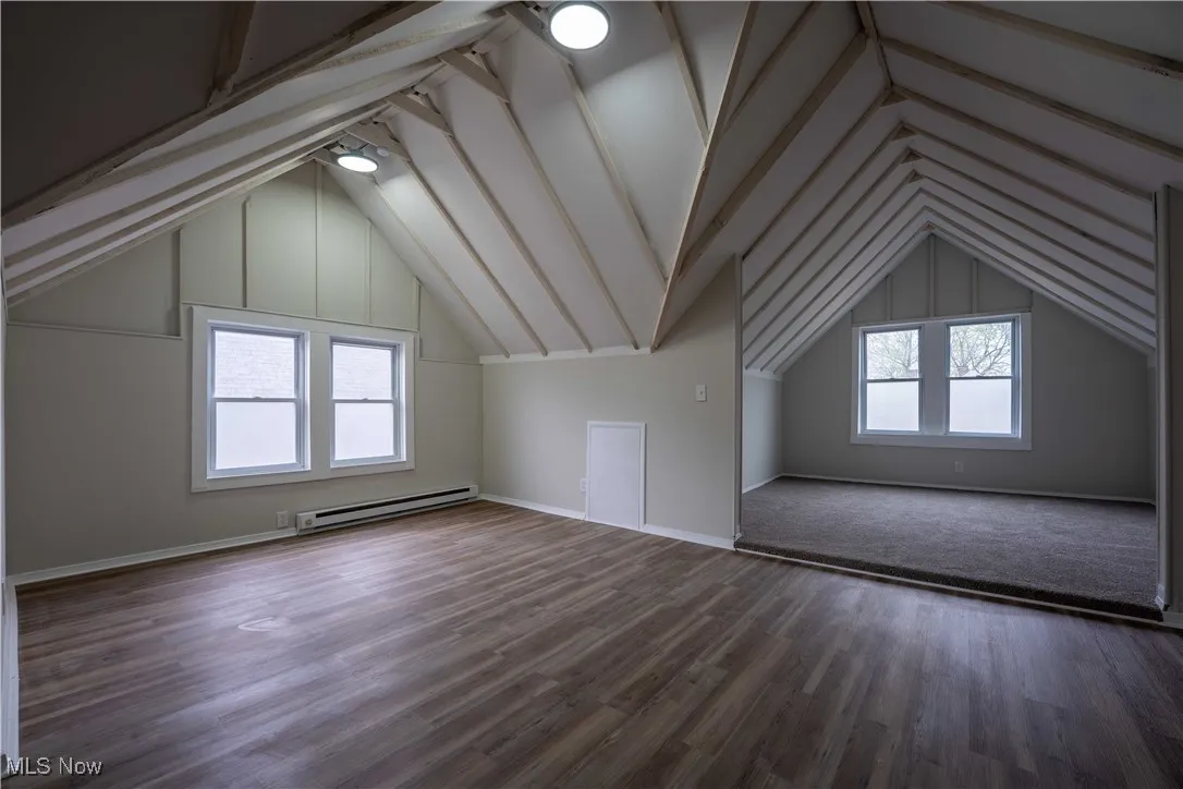 Bonus room featuring lofted ceiling, a baseboard radiator, and wood finished floors