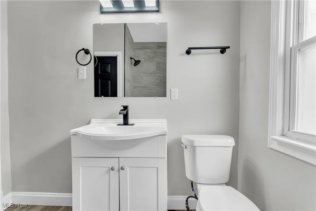 Full bathroom with vanity, tiled shower, and wood finished floors