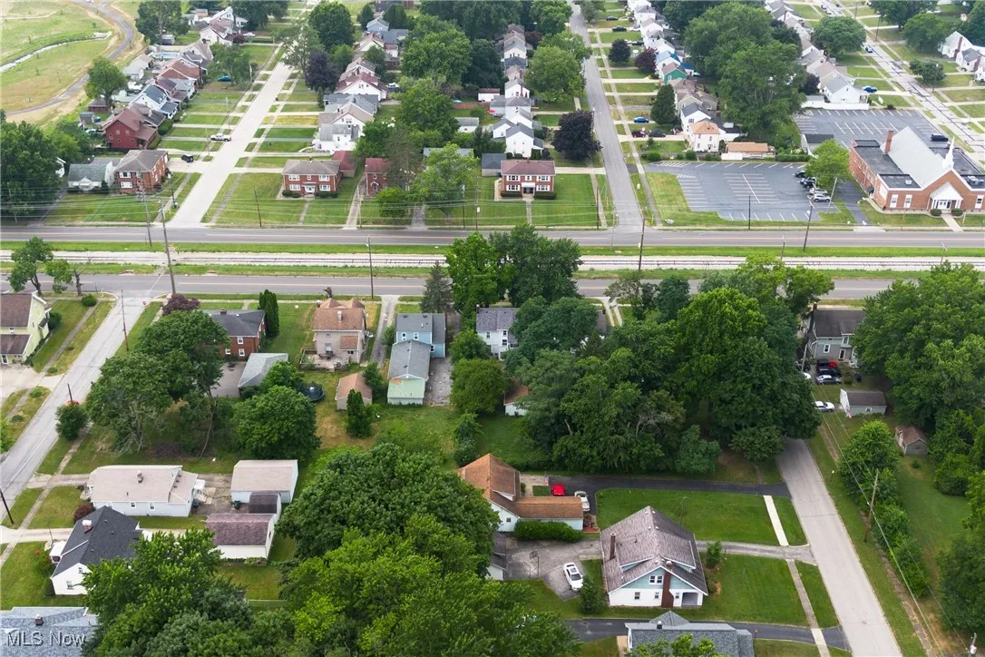 Aerial view of property and surrounding area with nearby suburban area