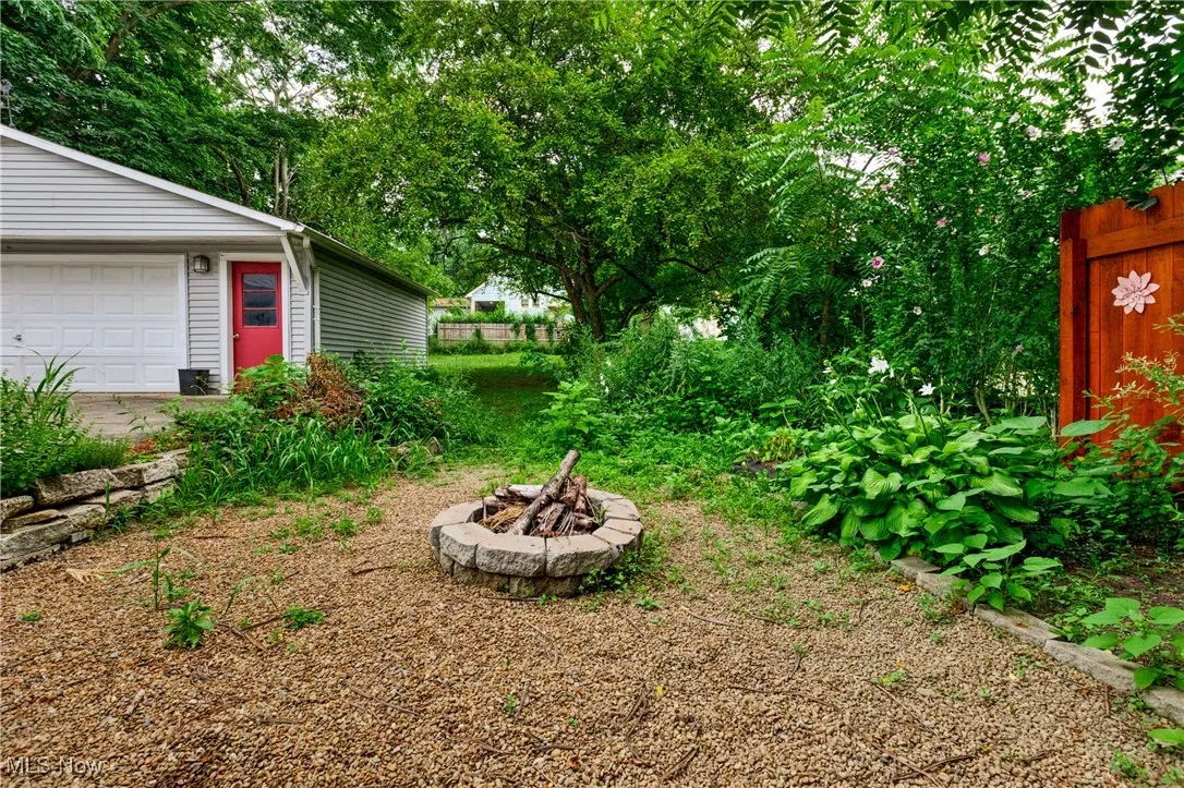 View of yard with a garage and a fire pit
