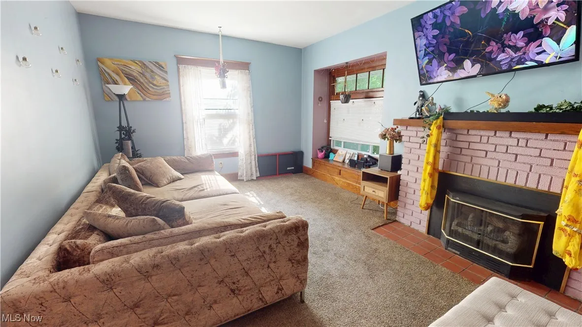 Living room featuring healthy amount of natural light, carpet, and a fireplace