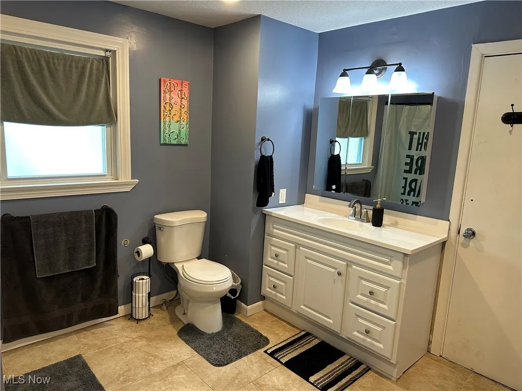 Full bath featuring vanity and toilet