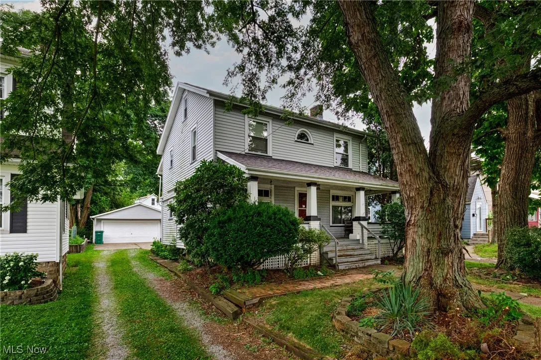 View of front facade with an outbuilding, a porch, and a garage