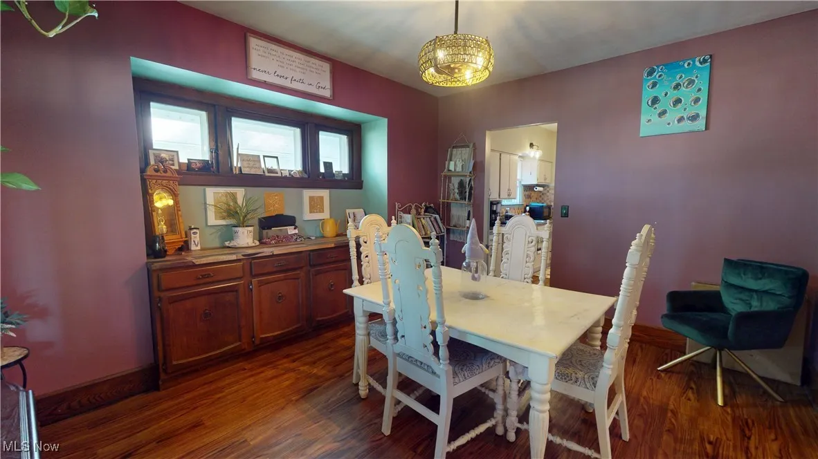 Dining room featuring dark wood finished floors and a chandelier
