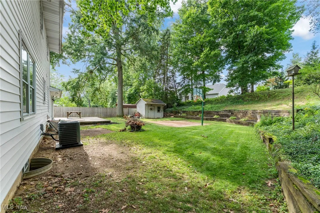 Fenced backyard featuring a storage unit and a patio area