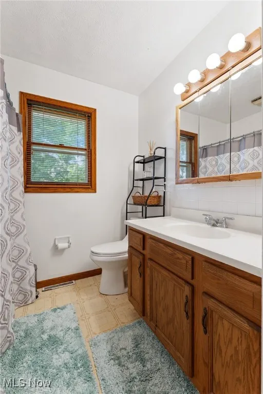Bathroom with vanity, tile patterned floors, and decorative backsplash