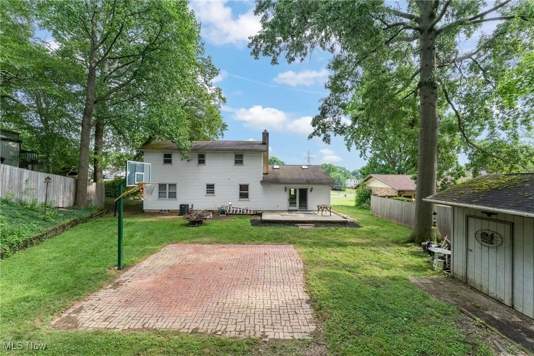 Back of house with a chimney, a patio, and a deck