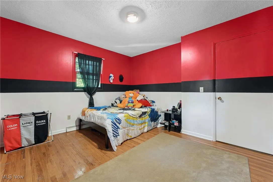 Bedroom featuring wood finished floors and a textured ceiling