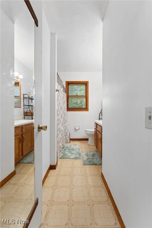 Full bath featuring vanity, tile patterned floors, and a shower with curtain