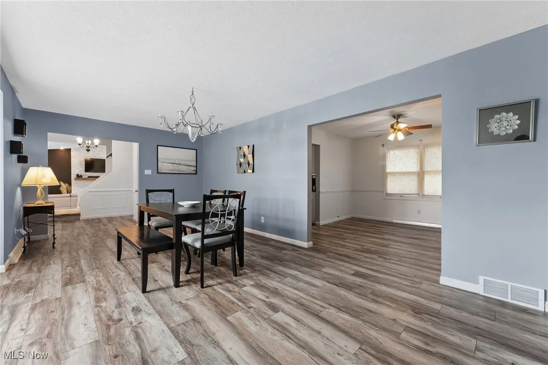 Dining area with a chandelier, wood finished floors, and ceiling fan