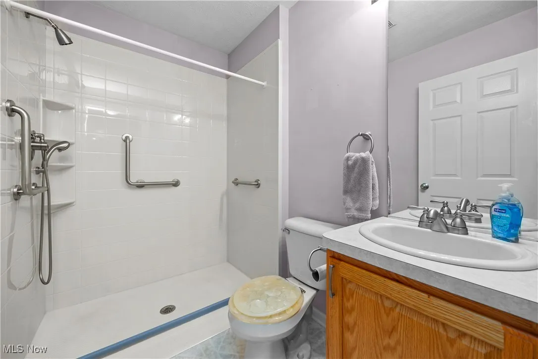 Bathroom featuring a tile shower and vanity