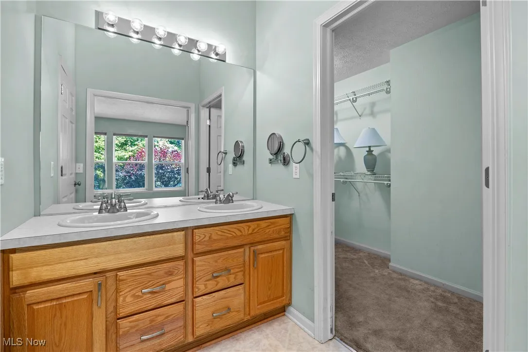 Bathroom featuring double vanity and a spacious closet