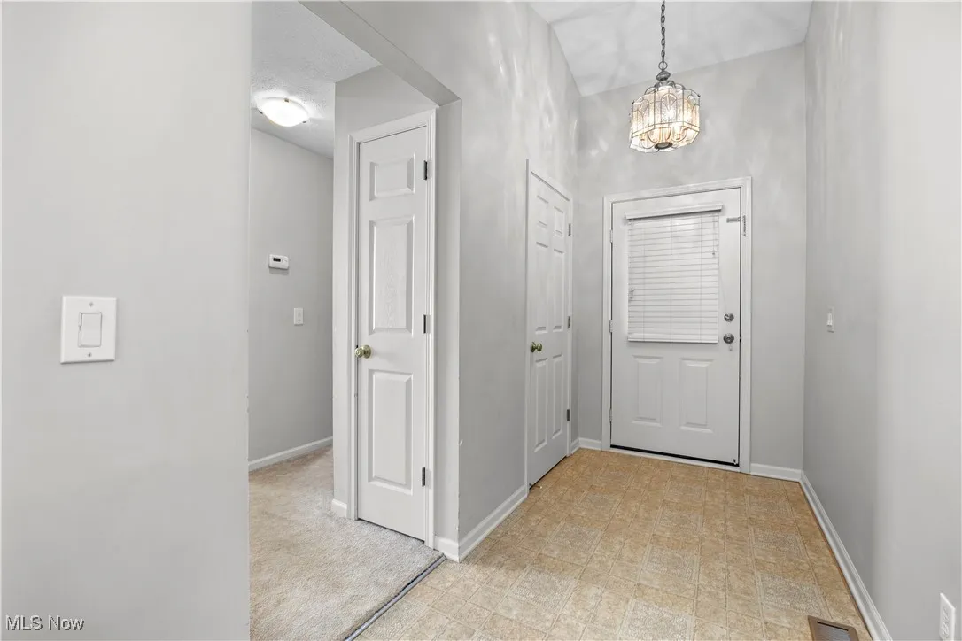 Corridor featuring a chandelier and light flooring