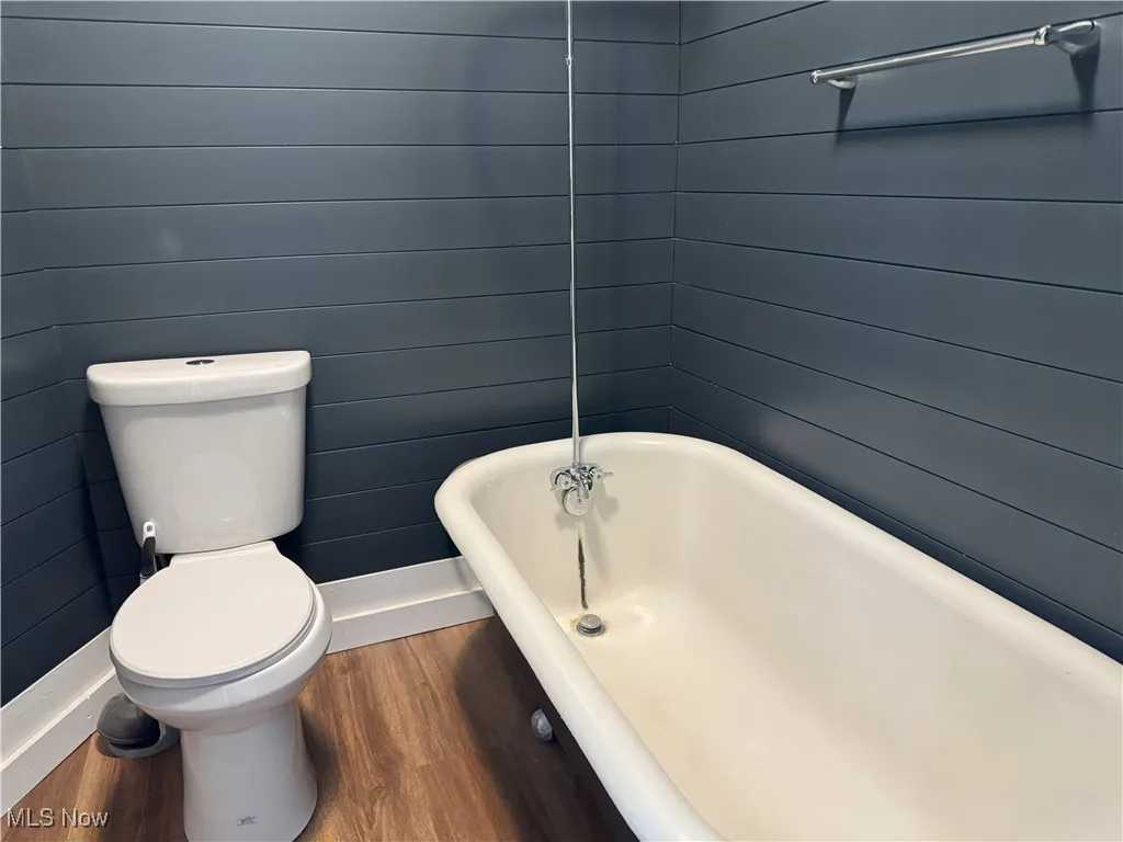 Bathroom with wood finished floors and a soaking tub