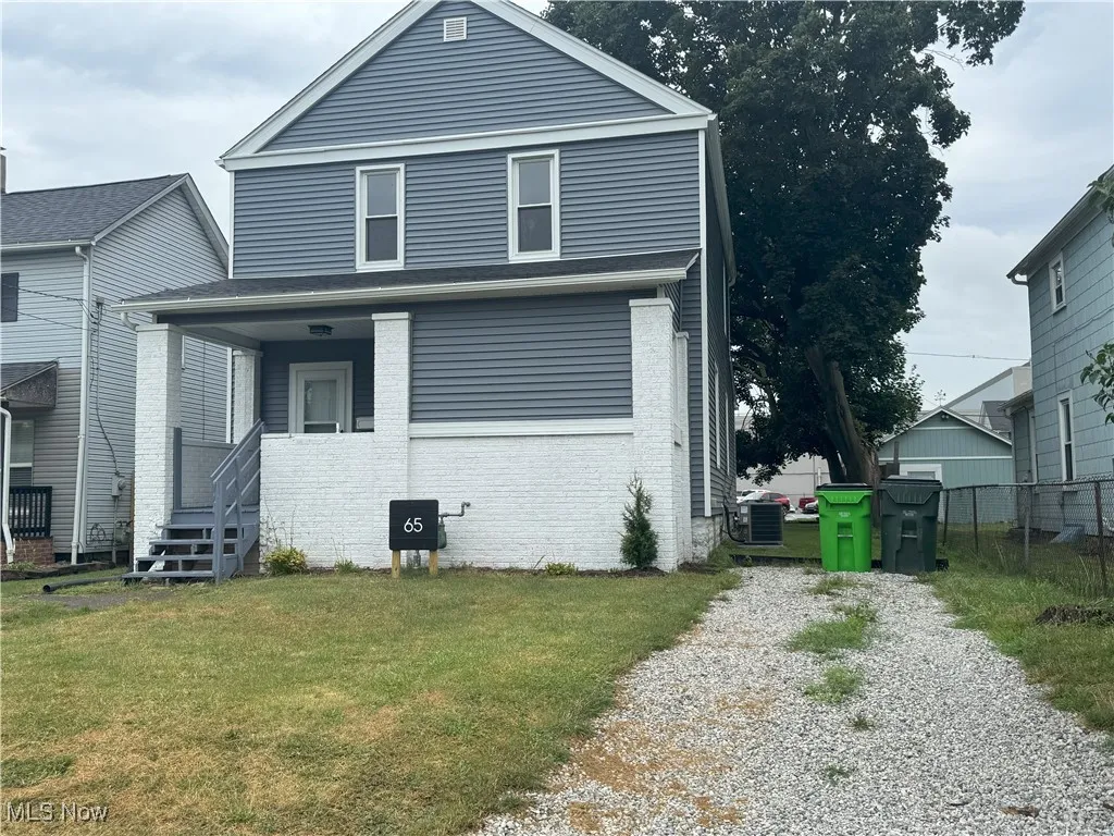 View of front of property with brick siding and gravel driveway