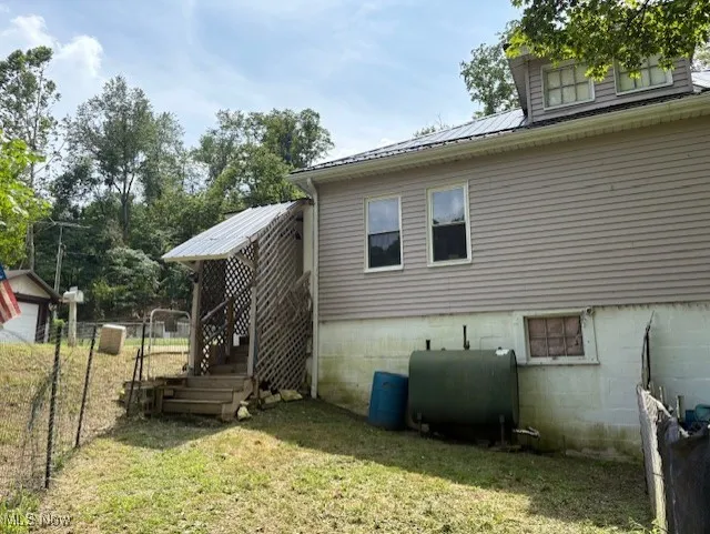 View of side of home featuring heating fuel and a metal roof