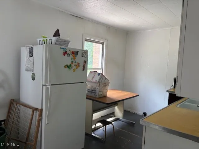 Kitchen with freestanding refrigerator and an office area