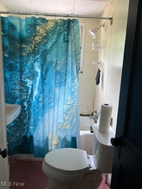 Full bathroom with shower / tub combo and toilet