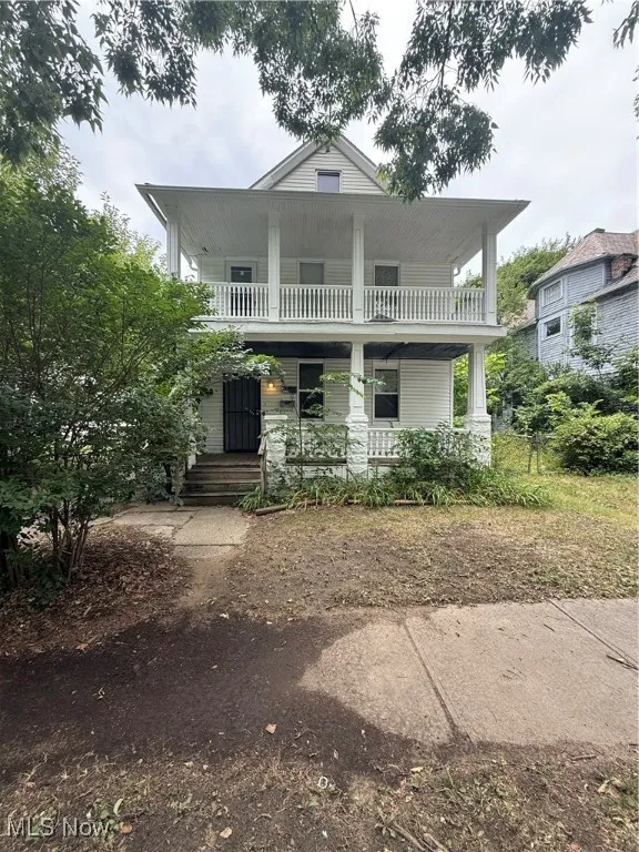 View of front of house featuring a porch and a balcony