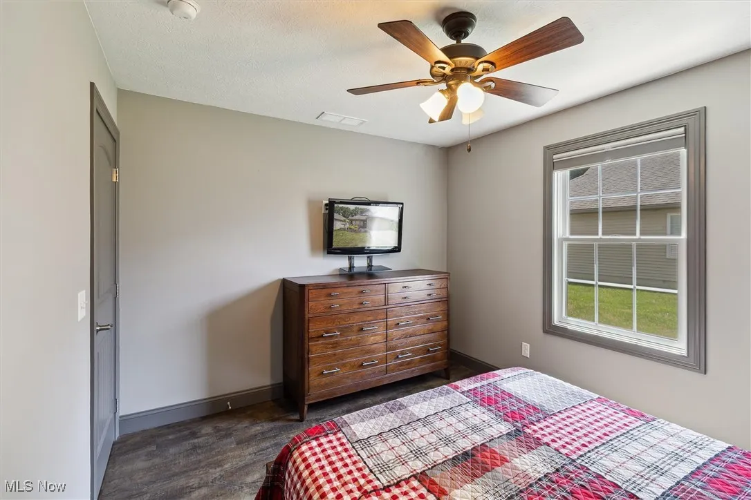 Bedroom featuring dark wood finished floors and a ceiling fan