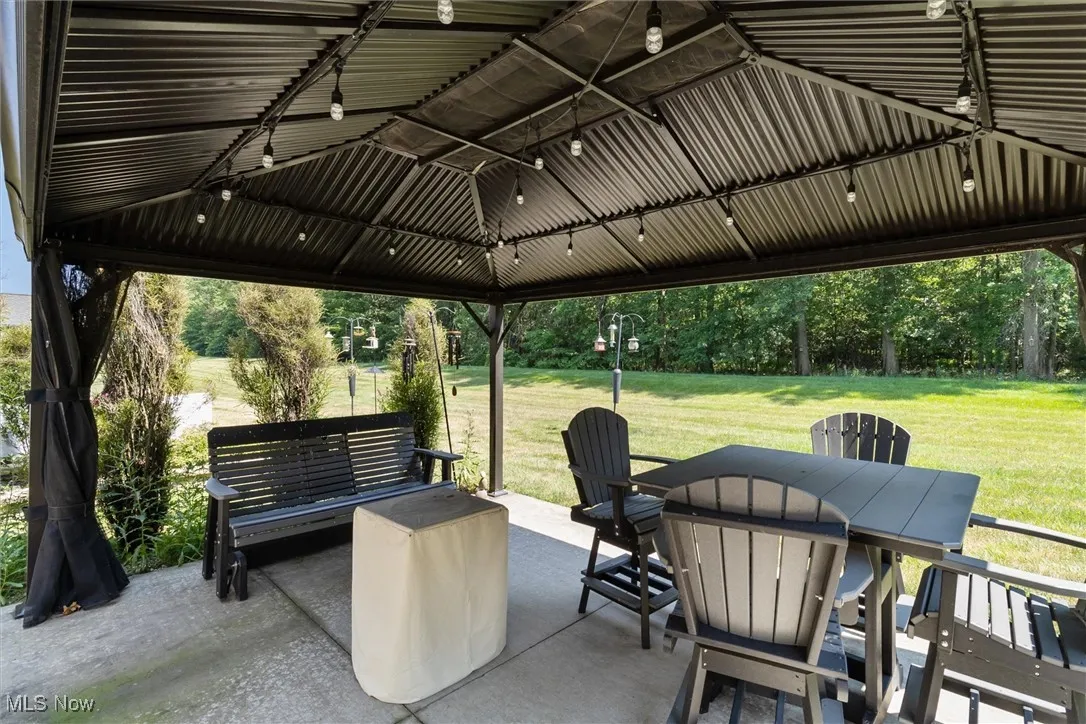 View of patio with outdoor dining space and a gazebo