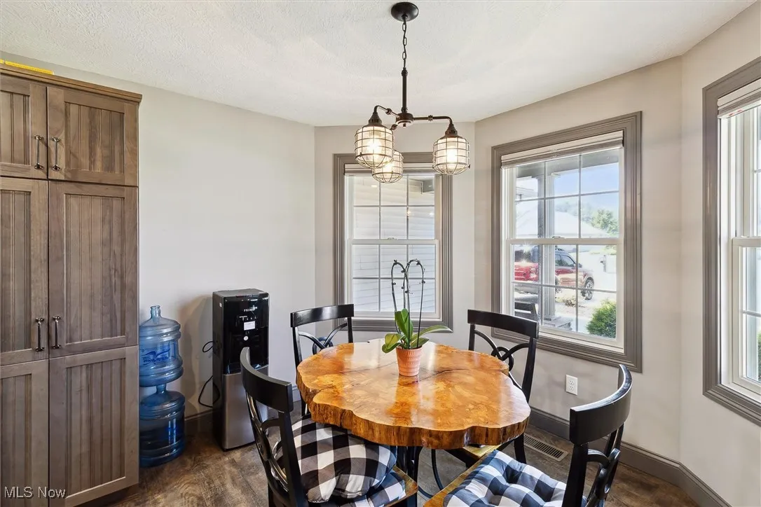 Dining area with dark wood finished floors and a chandelier