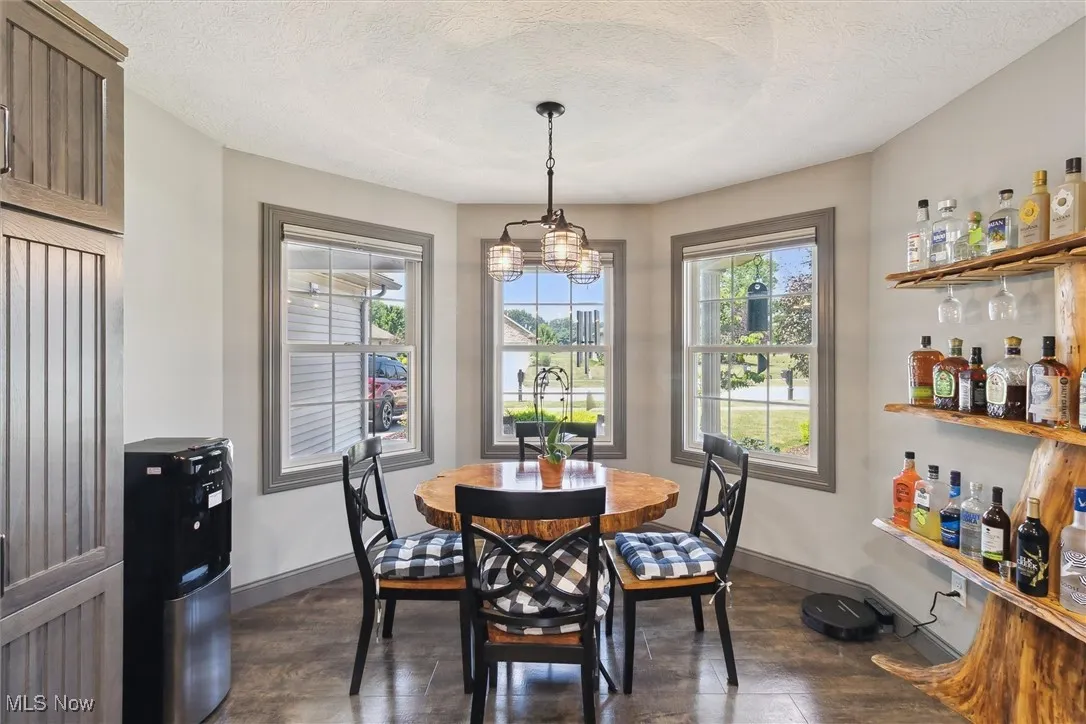 Dining area featuring a chandelier, a dry bar, and a textured ceiling