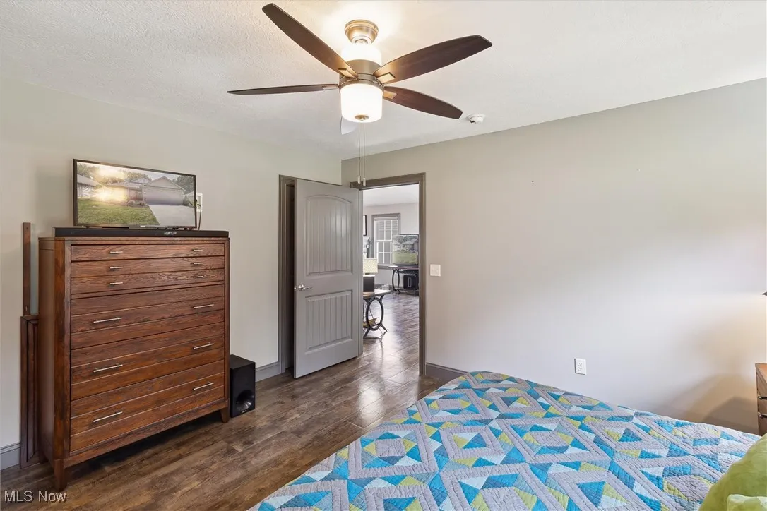 Bedroom with dark wood-style flooring and a ceiling fan