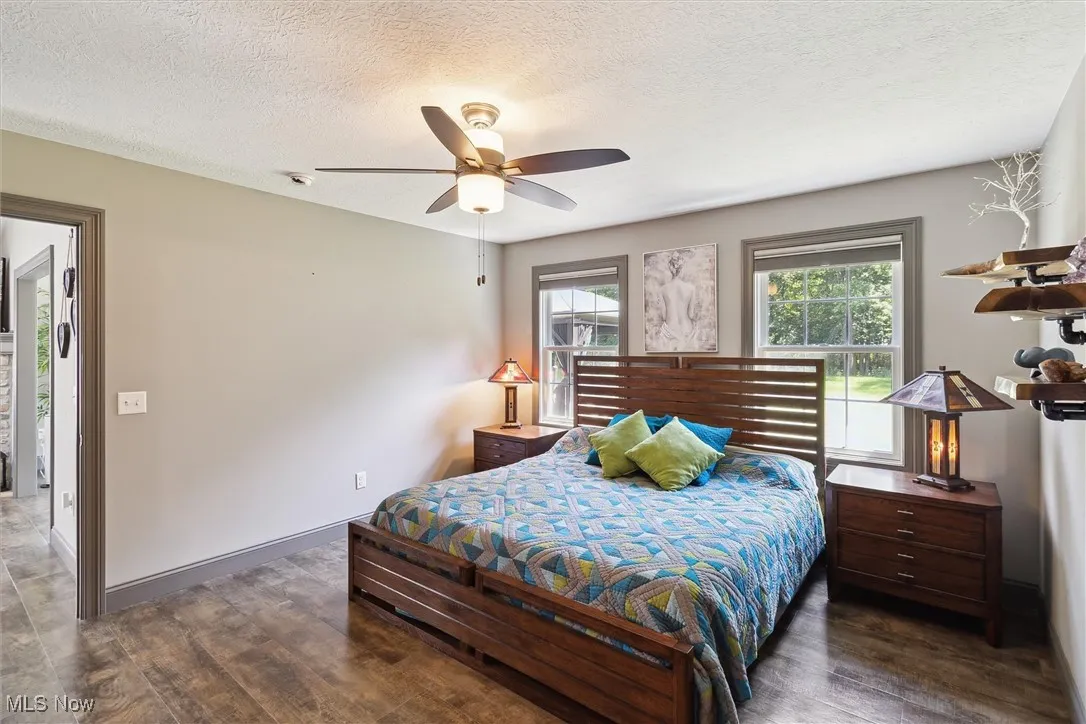 Bedroom with wood finished floors, a textured ceiling, and ceiling fan