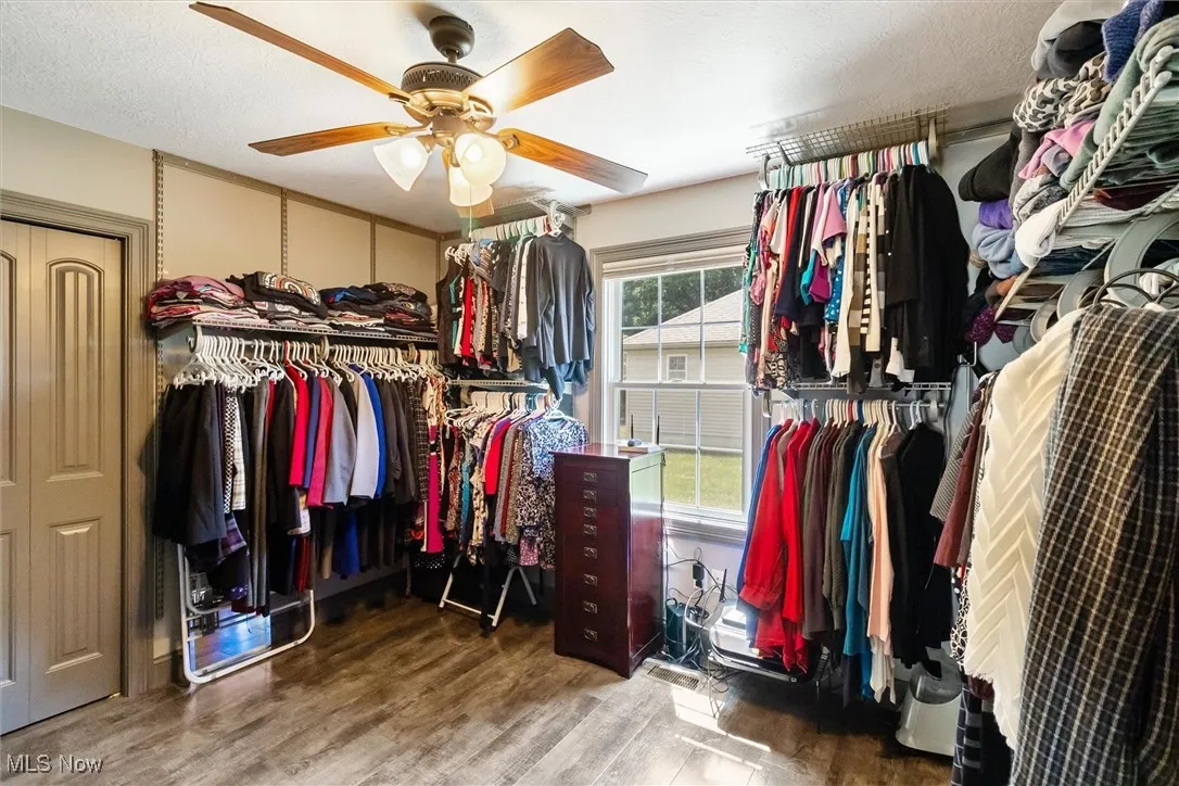 Walk in closet featuring wood finished floors and ceiling fan