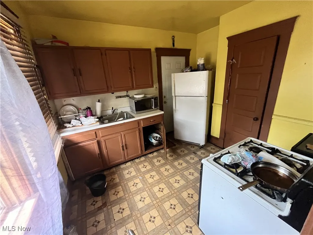 Kitchen featuring white appliances, light countertops, and light floors