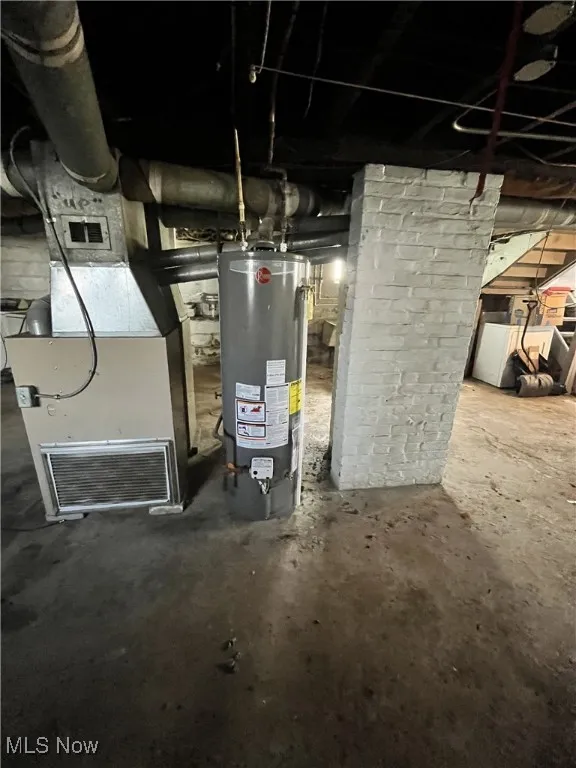 Utilities featuring heating unit, water heater, and washer / dryer
