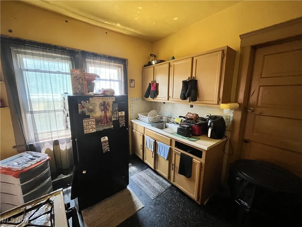Kitchen featuring freestanding refrigerator and light countertops