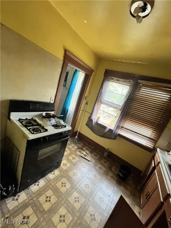 Kitchen featuring gas range and light flooring