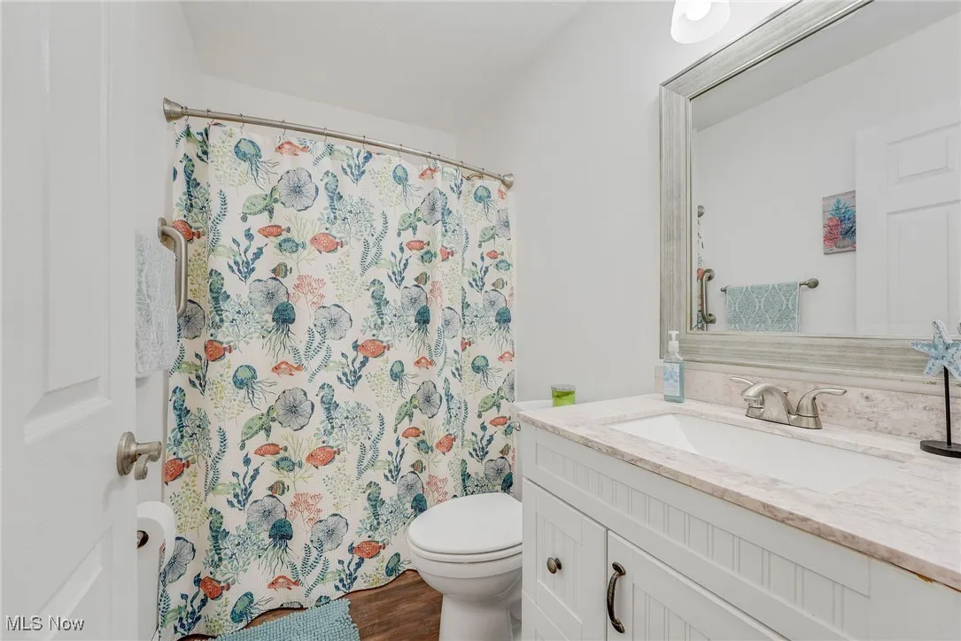 Bathroom featuring newer vanity, luxury vinyl floor and tub shower