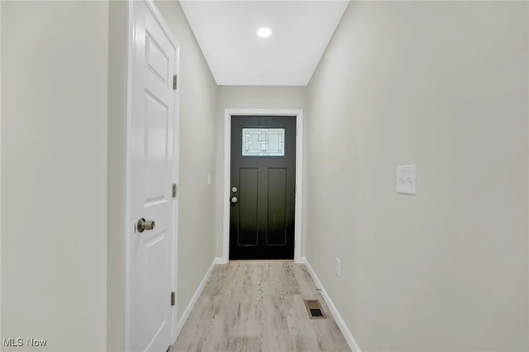 Entryway with light wood-style flooring and baseboards